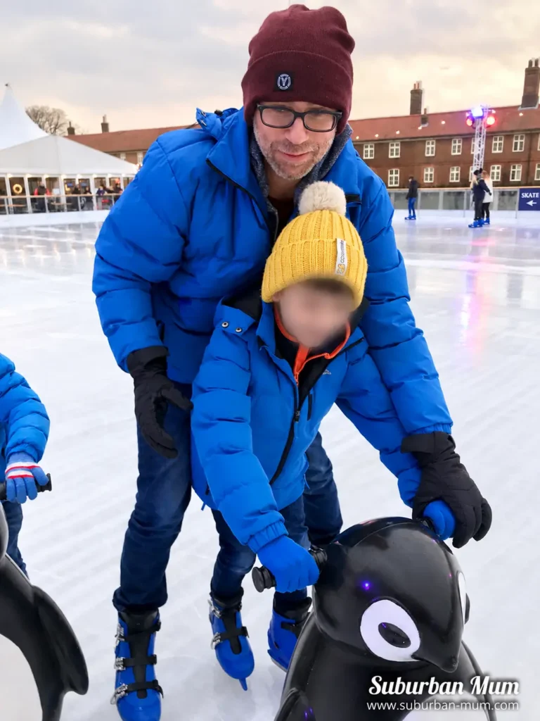 Child ice skating with a skate aid at Hampton Court Palace Ice Rink