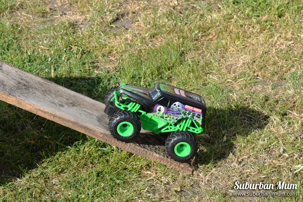 Monster Jam Grave Digger remote control car going up a ramp in the garden