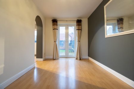 A brand new modern British home showing the dining room with newly fitted wooden floors looking out to the garden