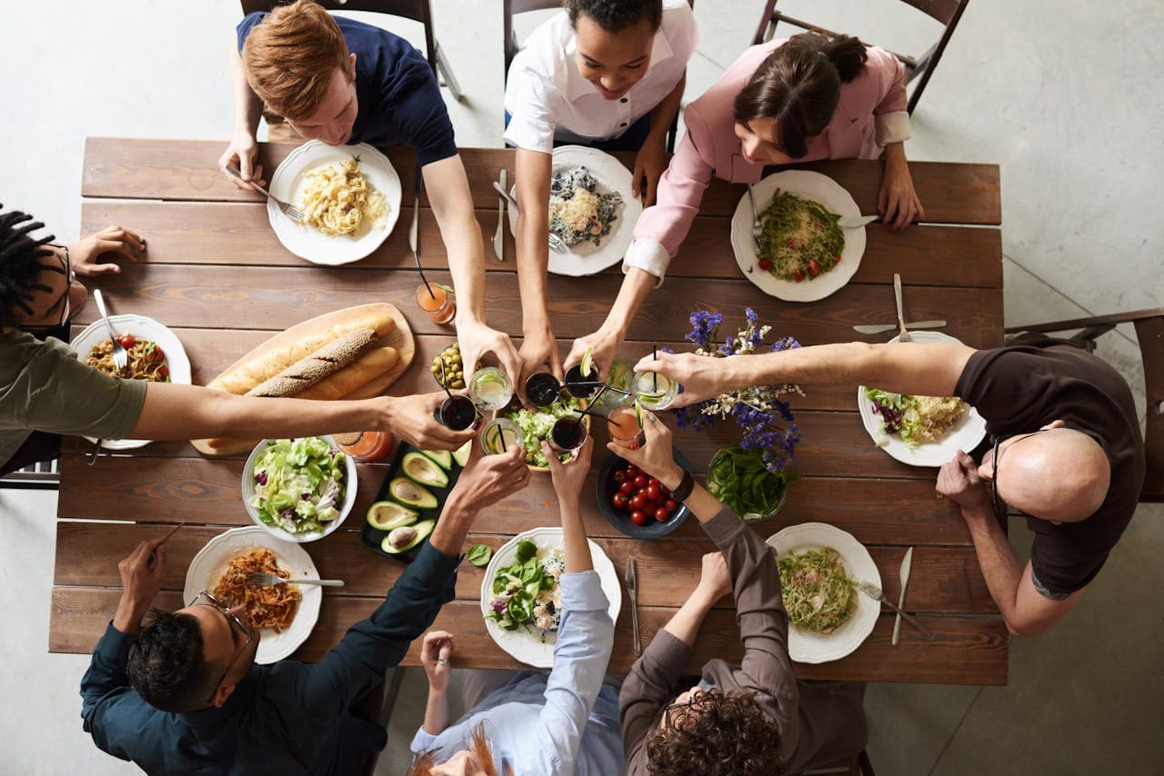 group of friends around a table with food