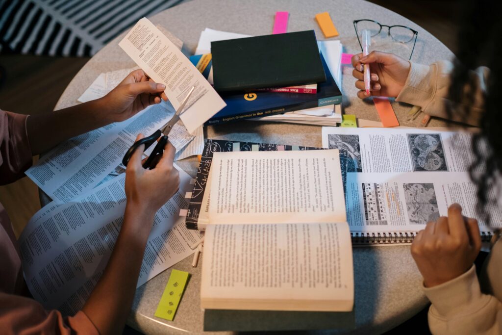 pexels-cottonbro-7128667 Young people studying together at a round table, focusing on their textbooks as if doing gcse revision and notes in a calm homework environment.