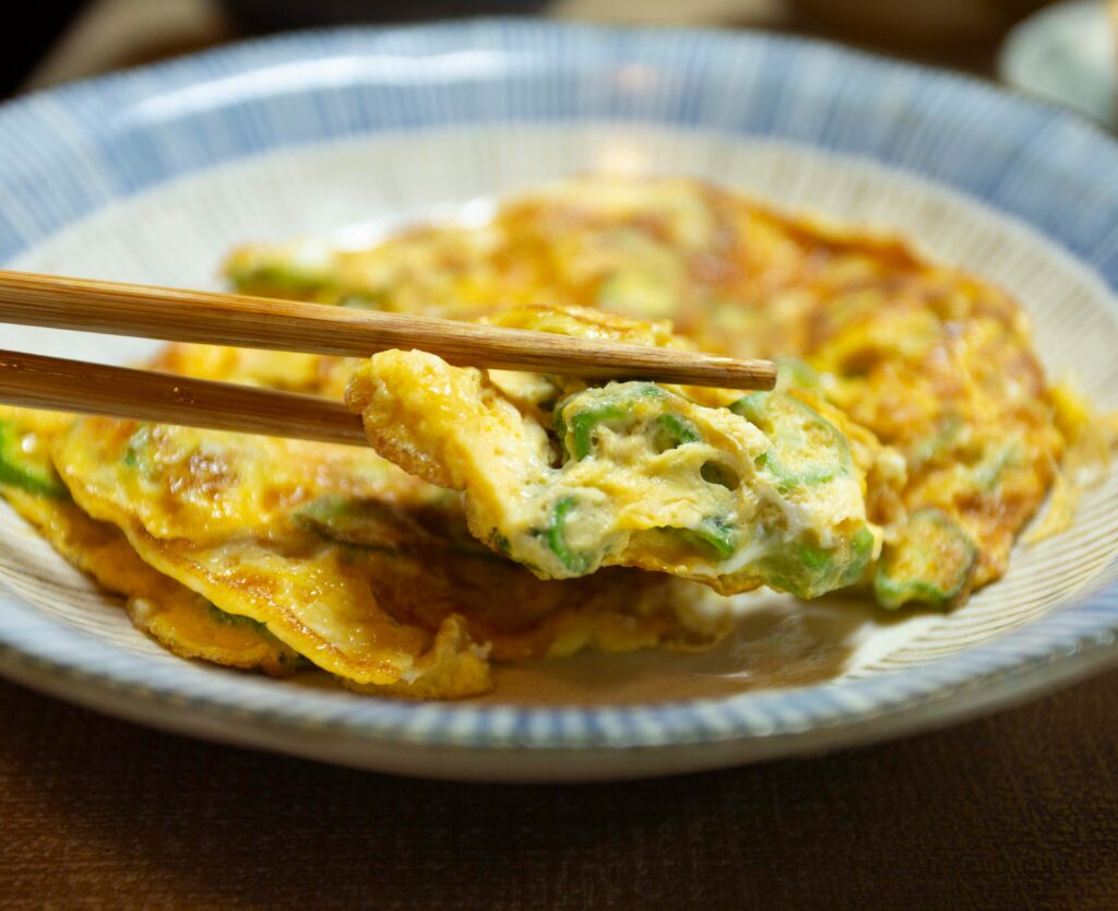 Close-up of a Japanese omelette served with chopsticks on a plate