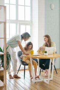 A parent teaching their daughter with gentle guidance, showing care, connection and learning together.