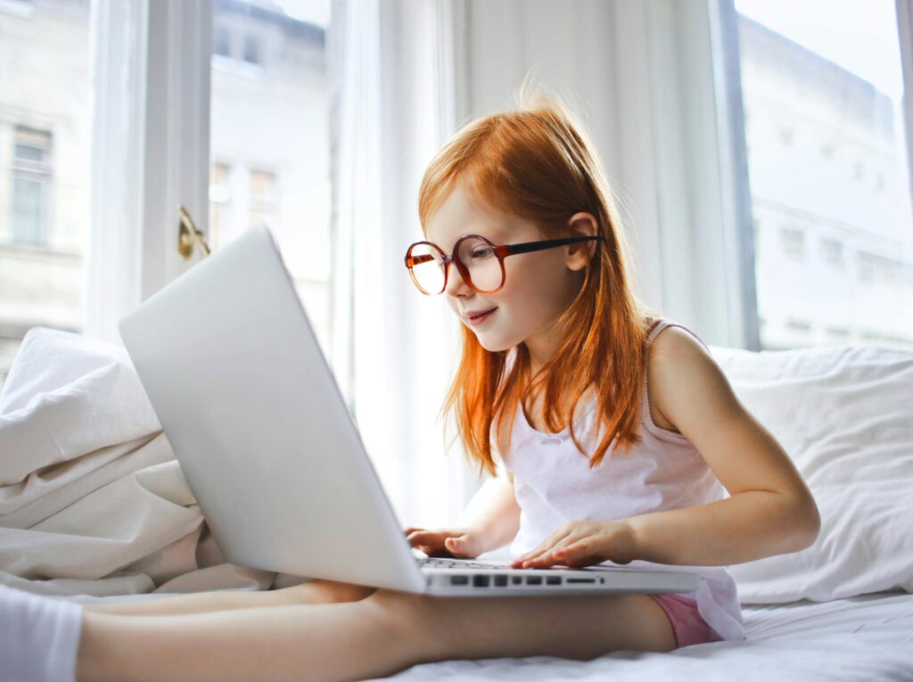 pexels-olly-3761512 “Young girl in glasses sitting in bed using a laptop