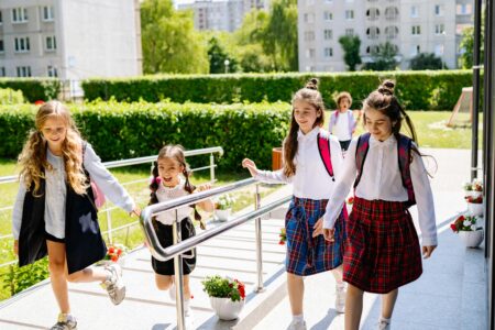 Schoolgirls in uniform walking together outdoors on their way to school