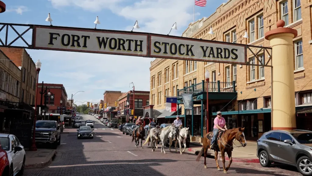 fort-worth-stockyards-texas Horse riders passing beneath the Fort Worth Stockyards sign in Texas